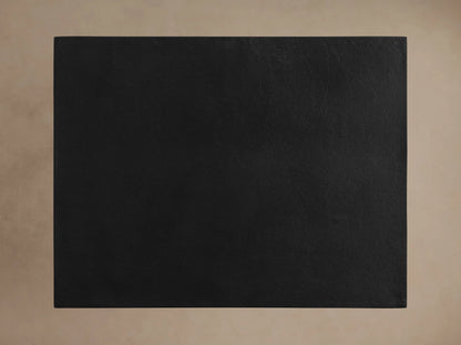 Soma C Table, top-down view of its rectangular black, textured tabletop against a light beige background.