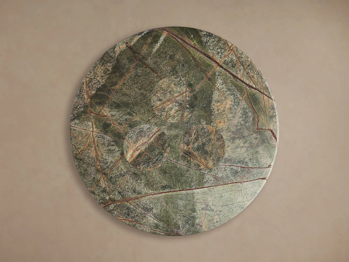 Top view of the round green Serafin Coffee Table with reddish-brown veins and three circular indentations.