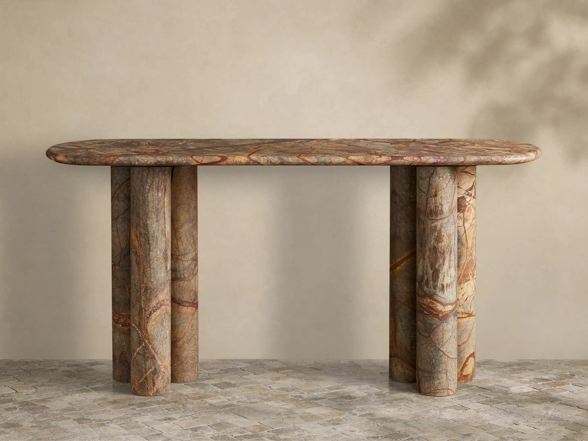 Front view of a multicolor marbled stone console table with an oval top and two clusters of three cylindrical legs.