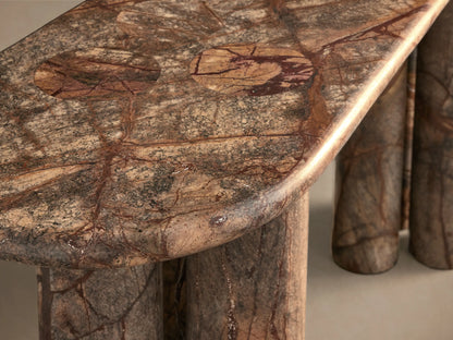 Front view of a reddish-brown Marble Console Table with an oval top and six cylindrical marble legs featuring natural veining.
