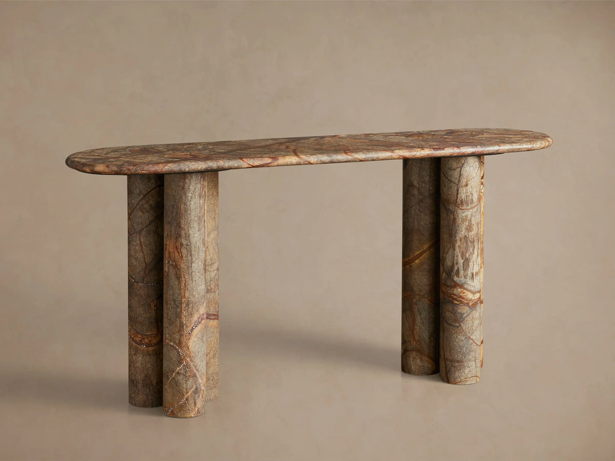 Close-up of a brown, grey, and reddish veined marble console table with two circular depressions and rounded edges.