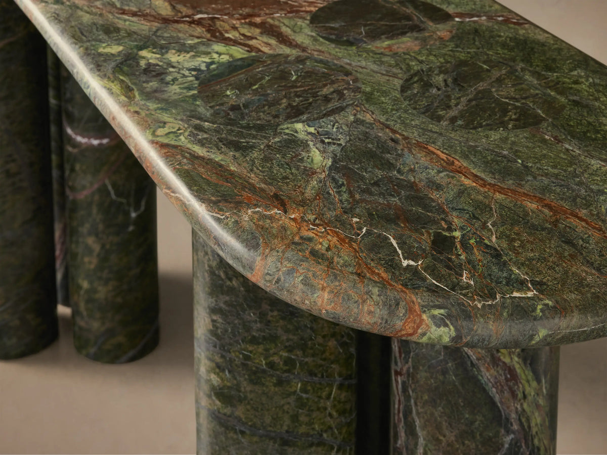 Front view of a console table with a mottled green and brown oval marble top, supported by two sets of three cylindrical legs.