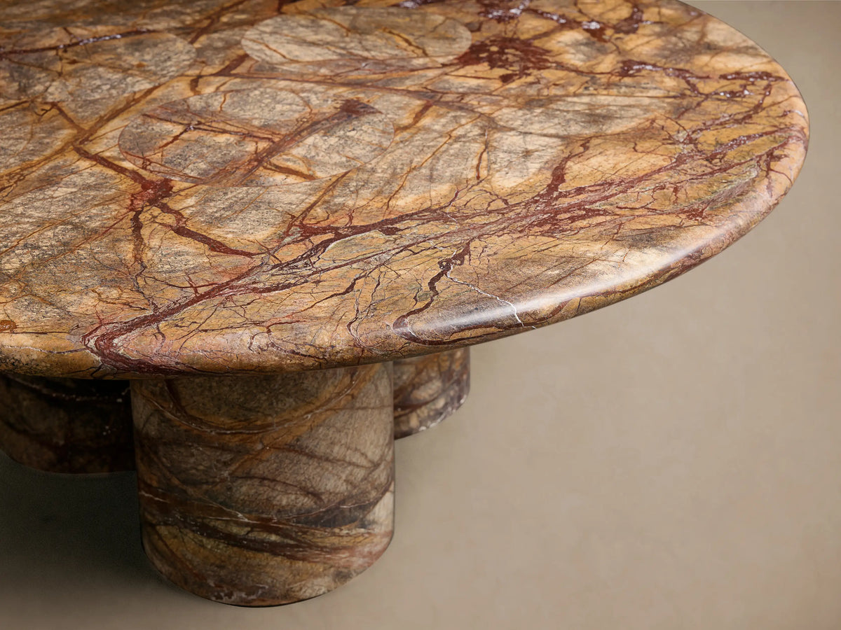 Top-down view of the Serafin Coffee Table, featuring a round marble top with intricate brown, gray, and reddish-brown veining.