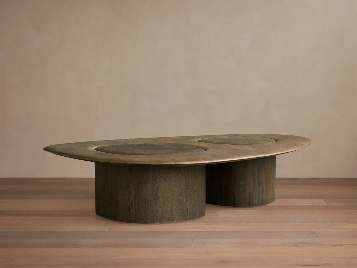 Organic-shaped Sucurro Coffee Table with an oxidized aluminum top showing patina and dark spalted primavera wood drum bases.