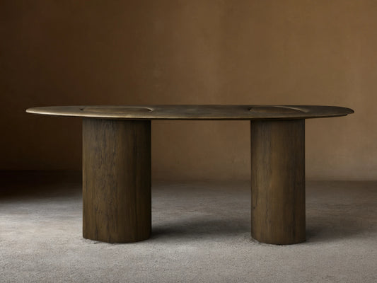 Sucurro Console Table: Dark oval oxidized aluminum top with recessed shapes & dimples, two thick cylindrical spalted wood bases.