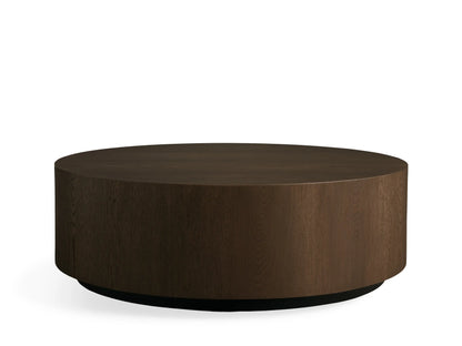 Sullivan Round Coffee Table, top view. Dark wooden tabletop with visible grain patterns, resting on a black base, set against a neutral background.