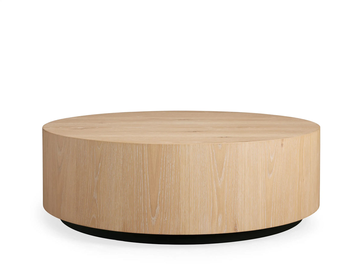 Sullivan Round Coffee Table made of light European oak, featuring natural cracks and knots, viewed from above on a beige background.