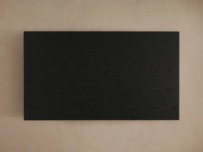 Sullivan Coffee Table with a close-up view of the black, wooden plinth-style base, showing natural oak grain patterns and textures.