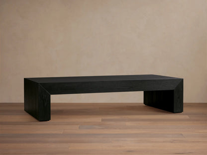 Sullivan Waterfall Coffee Table in dark oak finish, showcasing a smooth, elongated surface with seamless waterfall edges on a wooden floor.