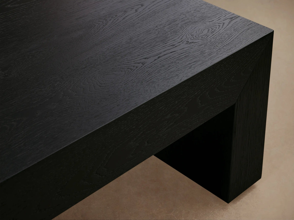 Sullivan Waterfall Coffee Table made of dark European oak with a smooth, matte finish, featuring a continuous grain waterfall effect, set against a neutral wall and wooden floor.