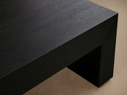 Sullivan Waterfall Coffee Table made of dark European oak with a smooth, matte finish, featuring a continuous grain waterfall effect, set against a neutral wall and wooden floor.