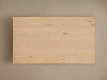 Sullivan Coffee Table corner view in solid oak with visible wood grain, resting on a black plinth-style base, showing natural texture.