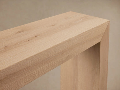 Sullivan Console Table made of solid oak, showcasing a waterfall edge design with visible natural wood grain and knots.
