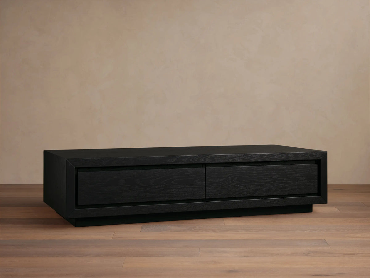 Dark brown wood Sullivan Storage Coffee Table with two soft-close drawers, styled with books and a decorative cloche.