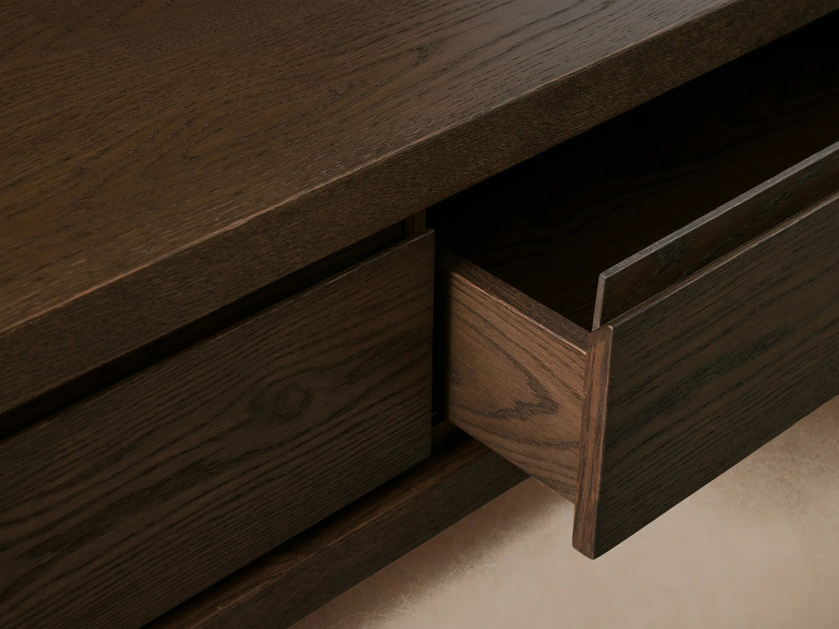 Sullivan Storage Coffee Table made of dark oak, featuring two soft-close drawers with finger pulls on a black plinth base.