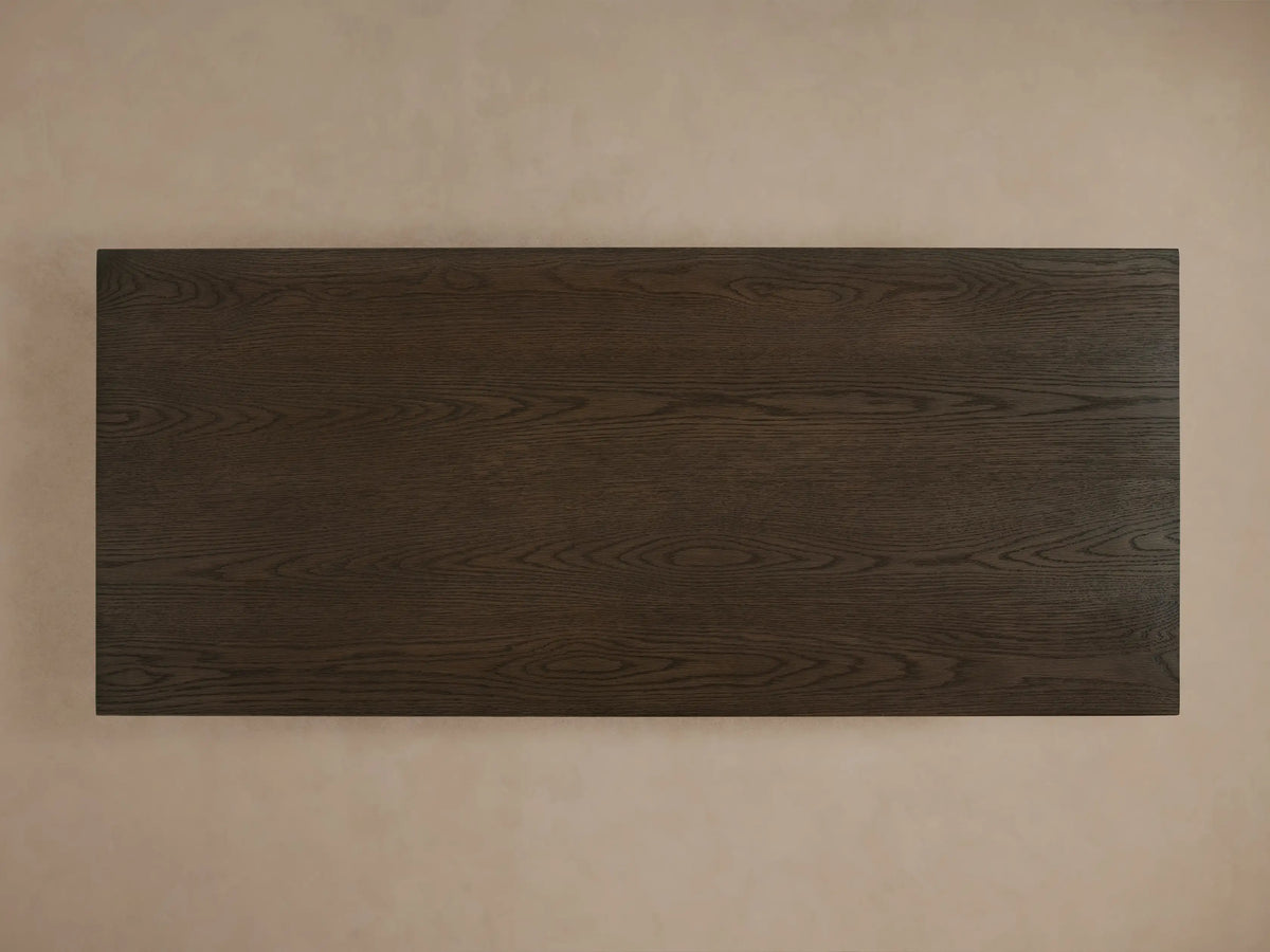 Sullivan Storage Coffee Table in dark oak finish, showing textured wood grain, with one soft-close drawer partially open and sleek finger pulls.