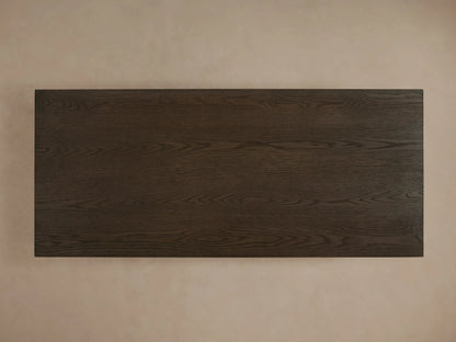 Sullivan Storage Coffee Table in dark oak finish, showing textured wood grain, with one soft-close drawer partially open and sleek finger pulls.