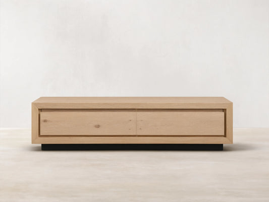 Sullivan Storage Coffee Table made of natural European oak with visible cracks and knots, on a black plinth base, front view.