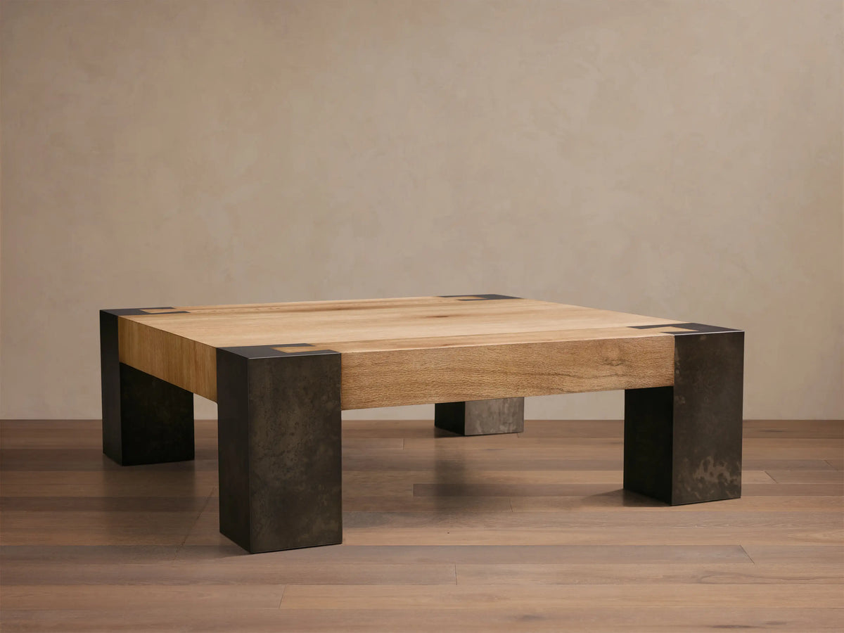 Front view of the Telluride Square Coffee Table, featuring a light oak wood top and dark, oxidized steel legs.
