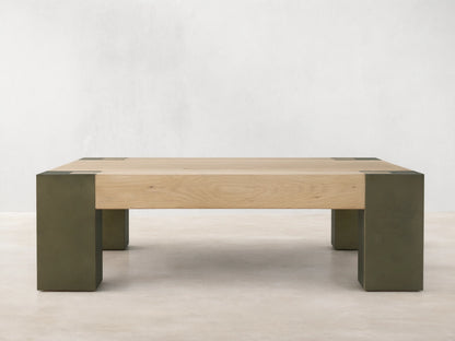 Light oak square Telluride coffee table with four legs of oxidized steel with dark patinas, against a beige wall and wood floor.