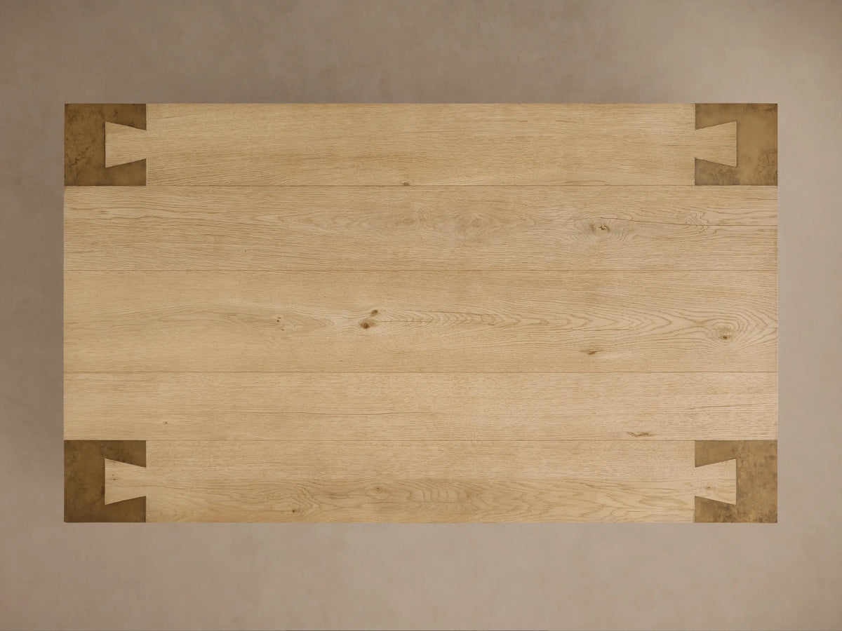 Close-up of Telluride Coffee Table corner. Light oak wood top with grain, joined to dark, weathered steel leg with intricate joint.