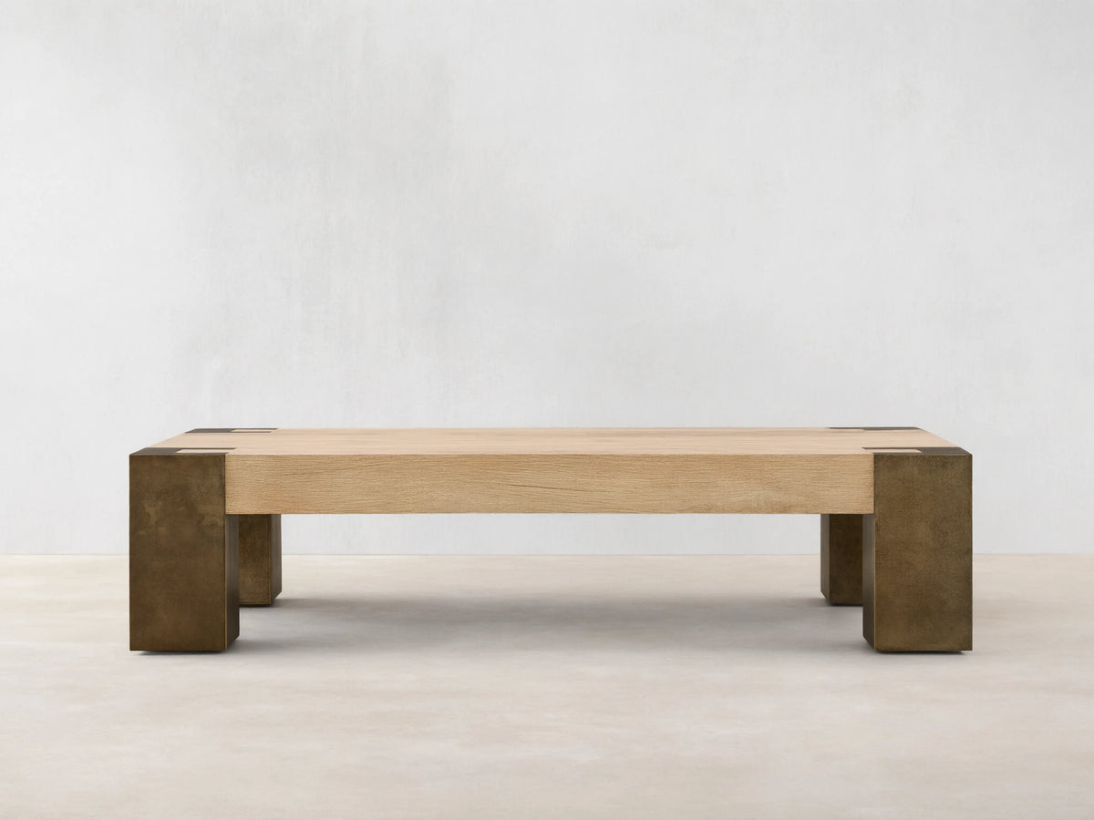 Telluride Coffee Table, light oak veneer top with visible grain, naturally oxidized steel legs & corner accents, on a wood floor.