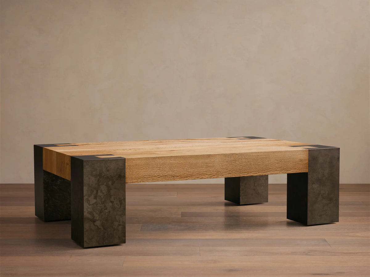 Front view of Telluride Coffee Table with light oak wood plank top on four dark, mottled oxidized steel block legs.