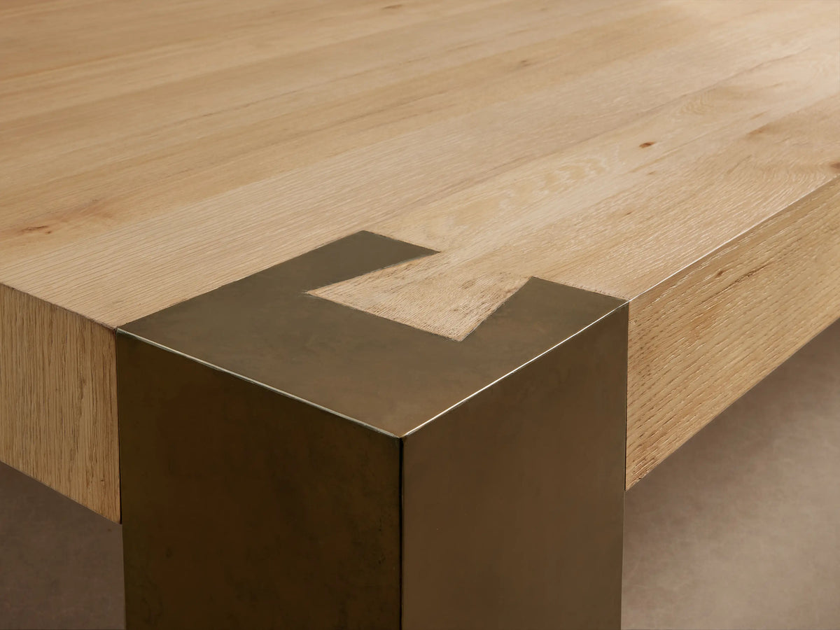 Telluride Square Coffee Table with a light natural wood top and four dark, oxidized steel square legs on a wooden floor.