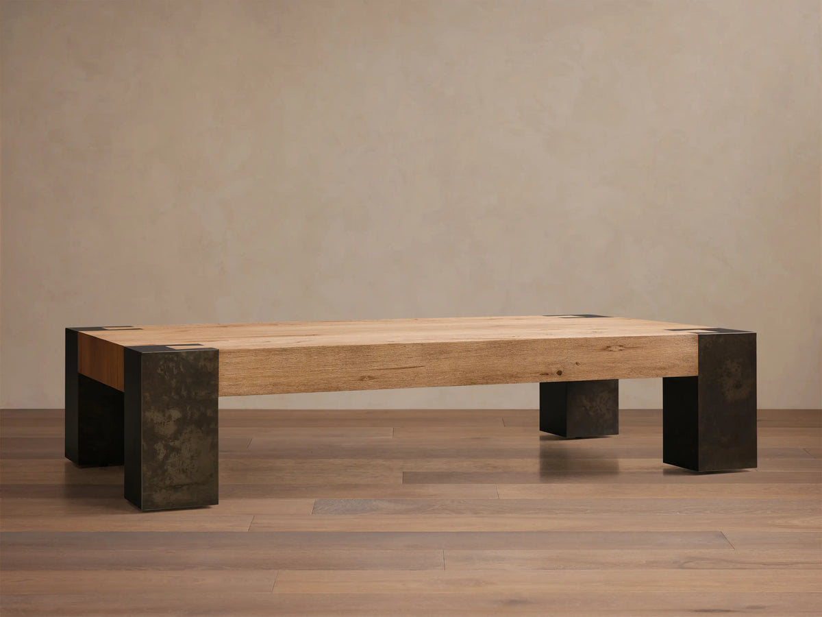 Front view of the Telluride Coffee Table, featuring a light oak veneer top and dark oxidized steel legs with mottled patinas.
