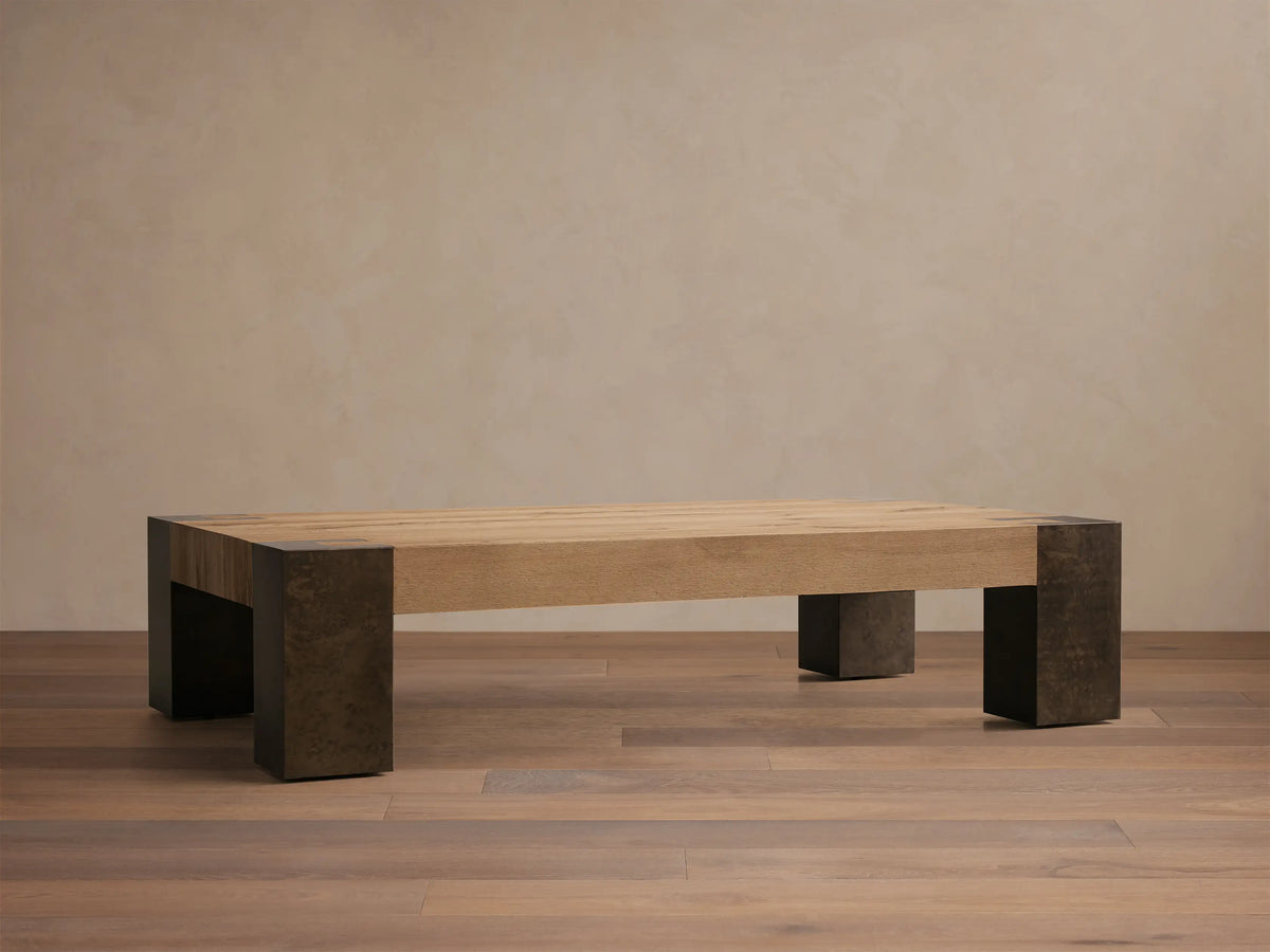 Front view of Telluride Coffee Table with a light natural oak wood plank top and dark, weathered steel legs and corner accents.