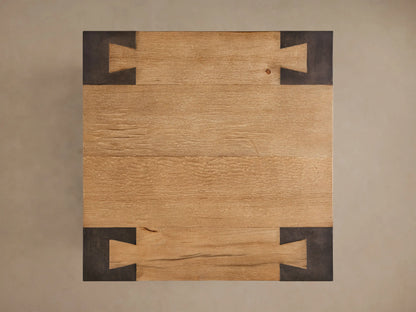 Close-up of the Telluride End Table, featuring light natural oak wood surfaces and dark oxidized steel legs with corner joinery.