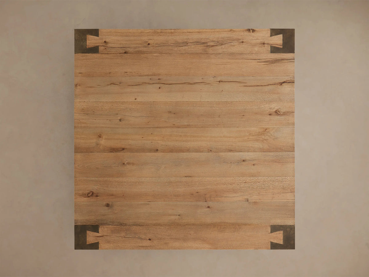 Close-up of the warm toasted oak veneer and dark oxidized steel interlocking corner of the Telluride Square Coffee Table.
