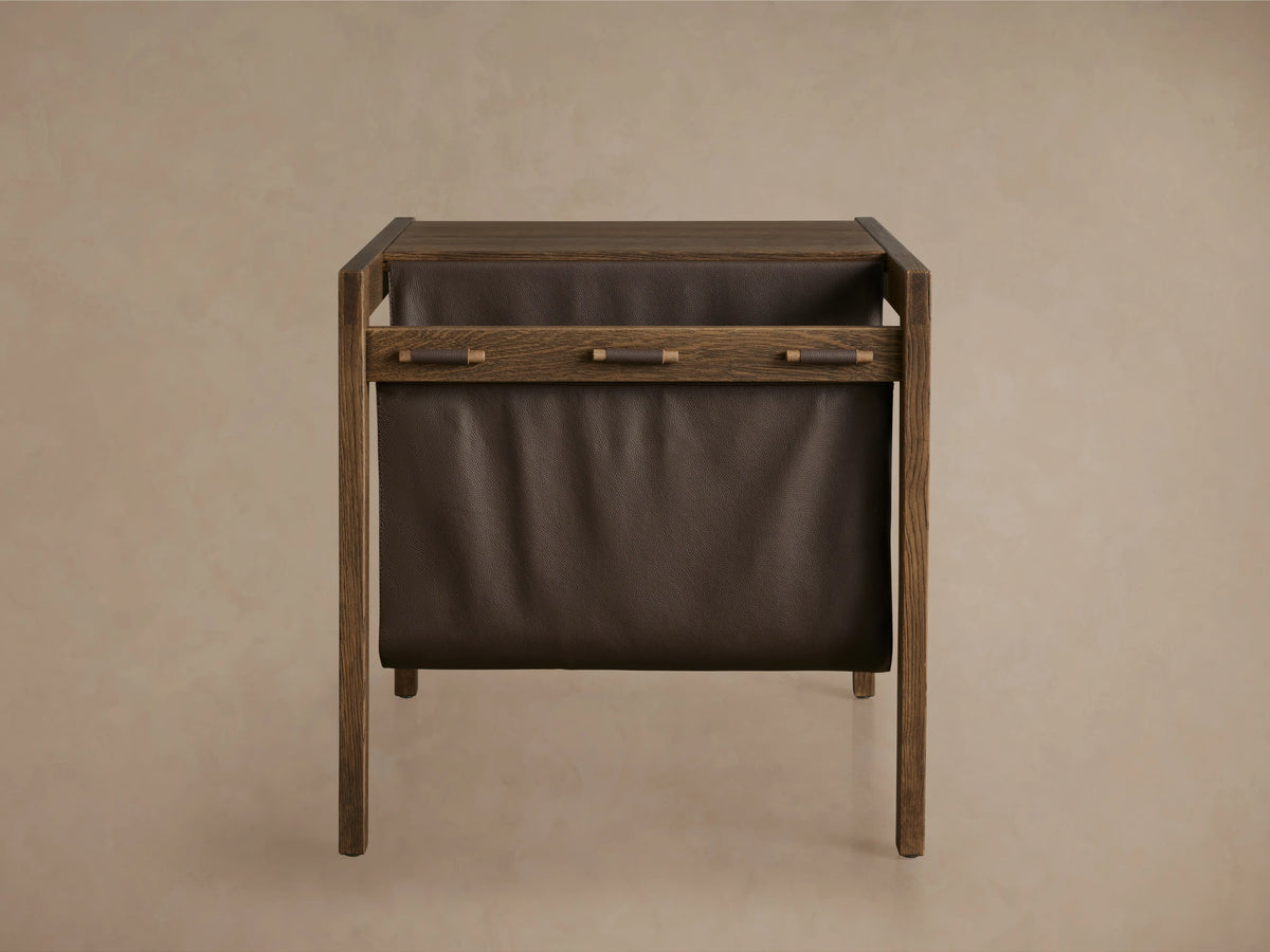 Top view of the Thorin Magazine Table, showing a solid oak wood surface with a brown leather sling held by wooden dowels.