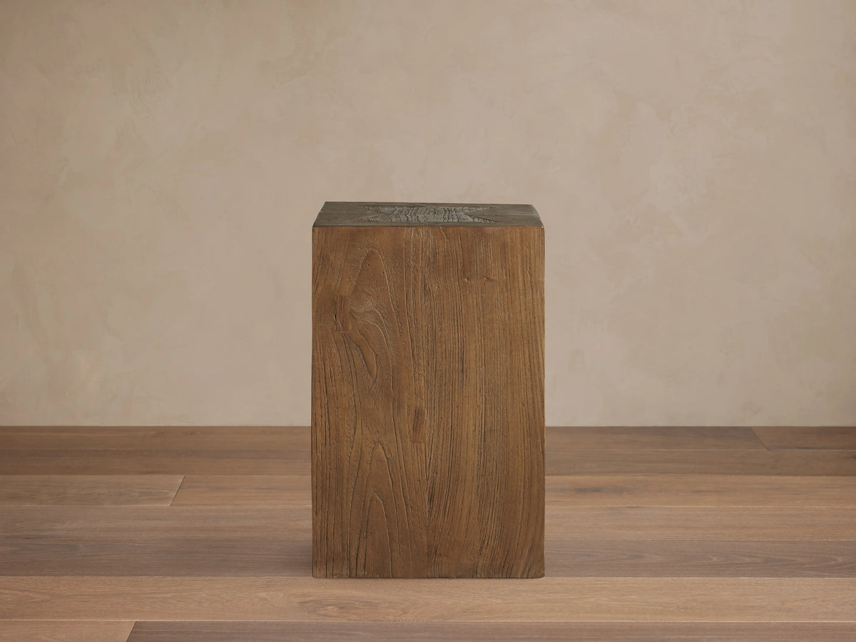 Square Ubud Pedestal made of reclaimed teak wood in a natural waxed finish. Displaying warm brown tones and wood grain texture.