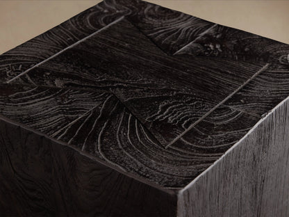 Ubud Pedestal, a rectangular block made of dark reclaimed teak wood with a rich, textured finish. Placed on a wooden floor.