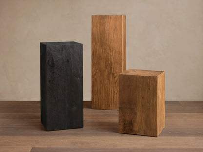 The Ubud Pedestal, displayed in rich black tones, features a charred, textured surface with visible wood grain and knot details.