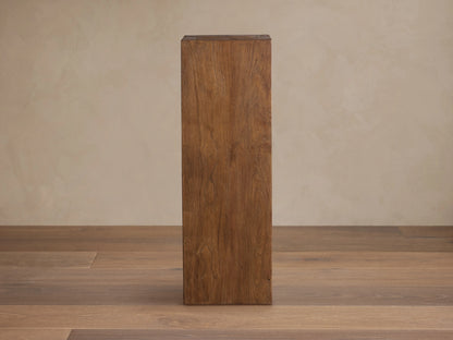 Tall, rectangular Ubud Pedestal made from reclaimed teak wood with warm brown tones and visible natural grain on a wooden floor.