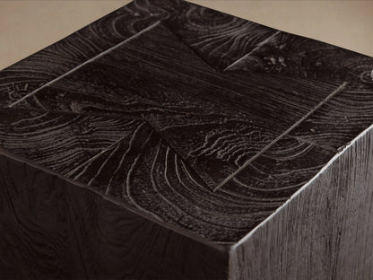 Tall rectangular Ubud Pedestal in dark, textured teak wood with visible grain patterns, standing on a wooden floor against a beige wall.