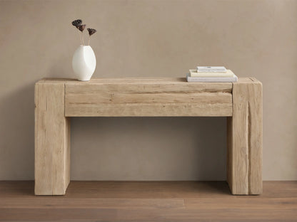 Front view of the Driftwood Ubud Console Table, a rustic reclaimed teak wood table with thick block legs, adorned with a white vase and books.