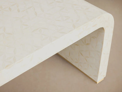 Visola Coffee Table with ivory-colored resin and camel bone surface showing delicate patterns, curved edge, and smooth finish.