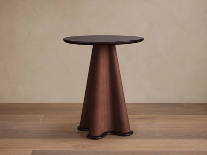 Volant Leather End Table with a dark brown round top and a sculptural leather-wrapped conical base, on a wooden floor.