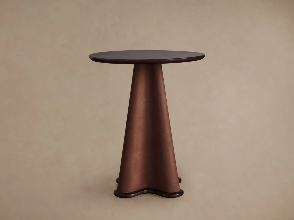 Volant Leather End Table featuring a round dark top and conical leather-wrapped base with wood accents, against a neutral background.