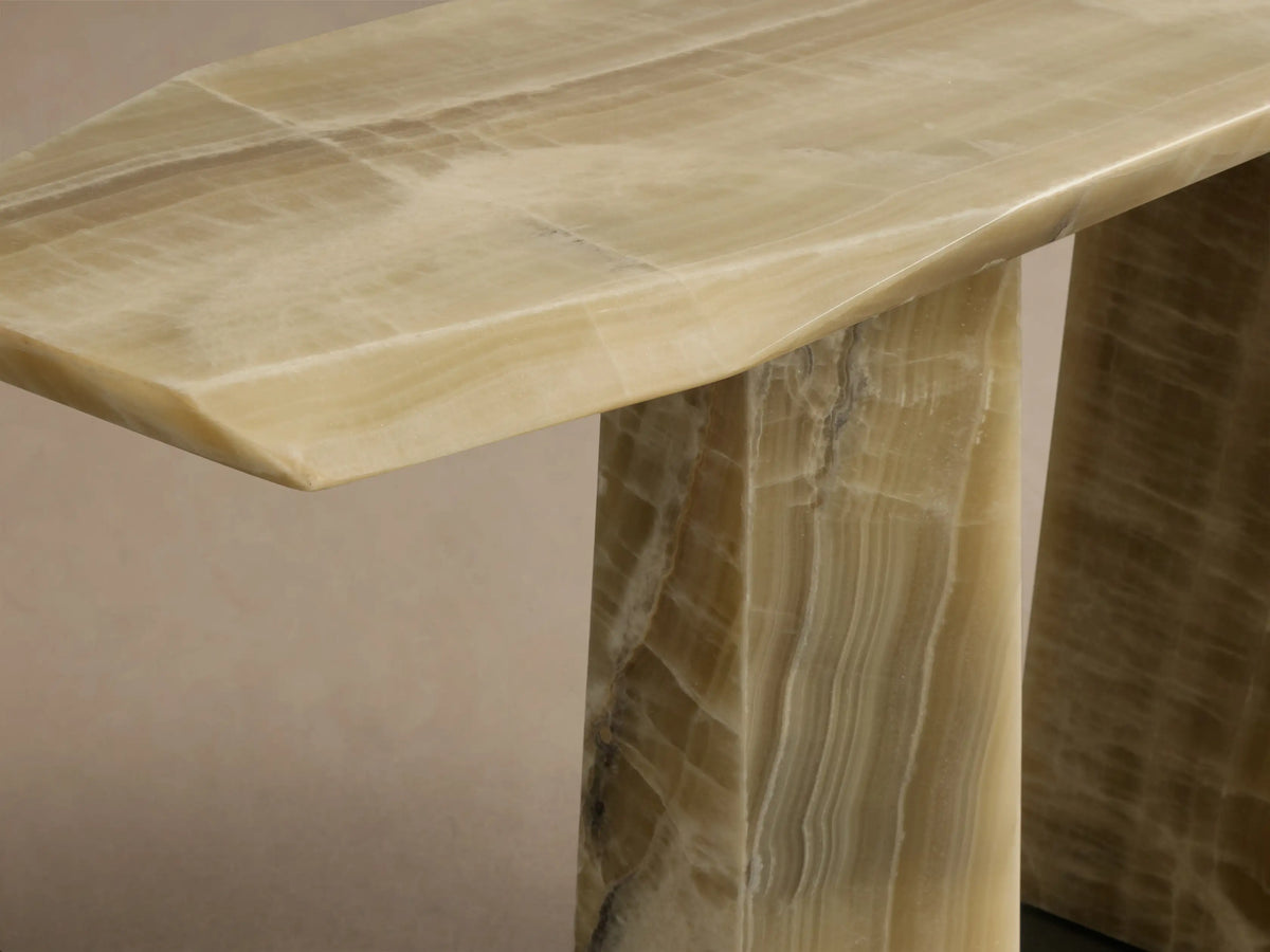Close-up of the green onyx Zyra Console Table, showing its asymmetrical tabletop and natural veining on the pedestal base.