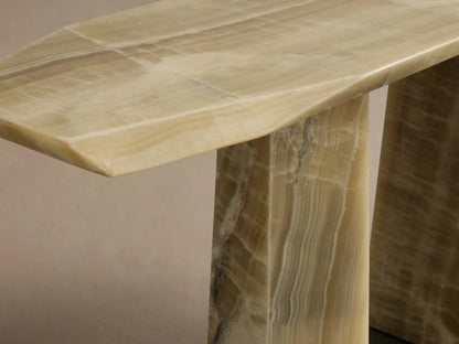 Close-up of the green onyx Zyra Console Table, showing its asymmetrical tabletop and natural veining on the pedestal base.