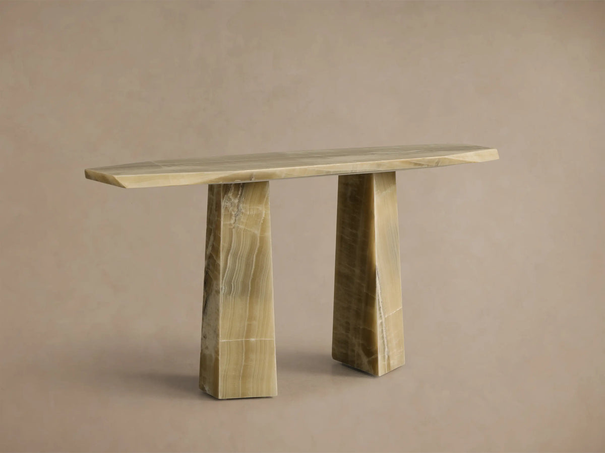 Front view of the green onyx Zyra Console Table. It features an asymmetrical top and two split pedestal bases with natural veining.