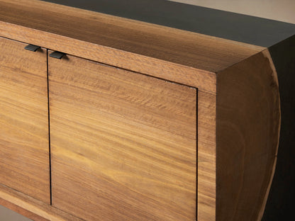 Acacius Media Console with four wooden cabinet doors, each with subtle grain patterns, set against a smooth, dark top in a neutral setting.