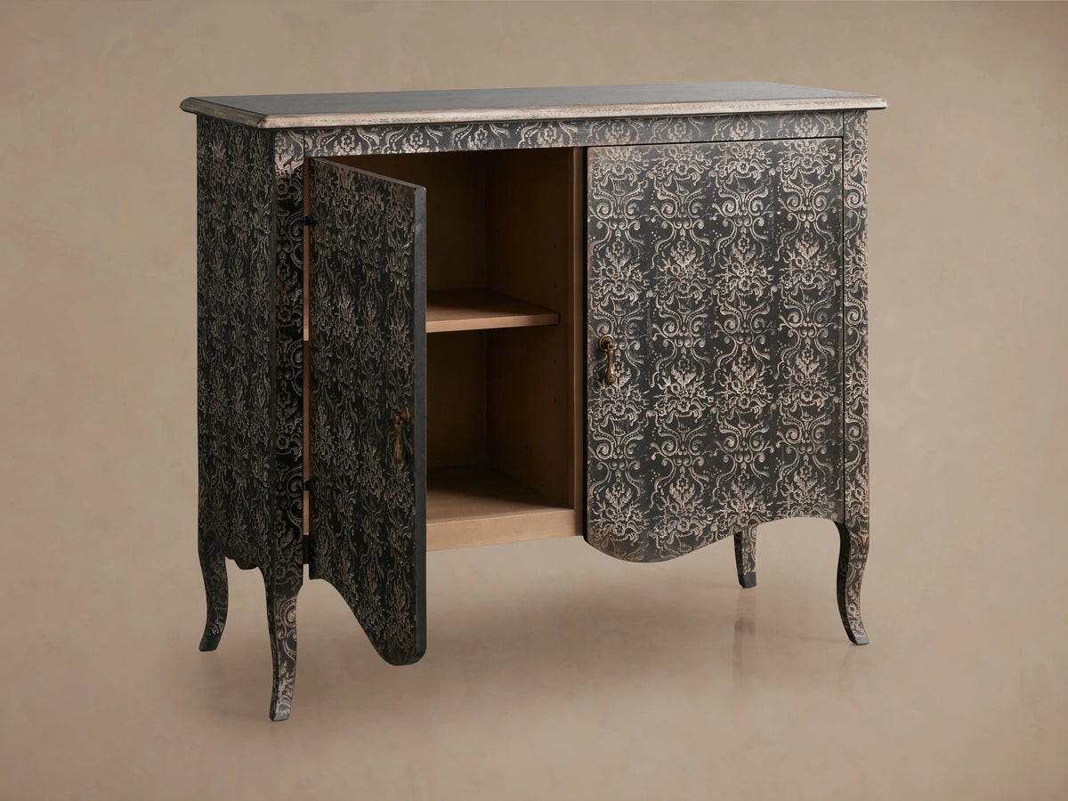 Amalfi Cabinet with ornate hand-carved design in dark antique finish. Open door reveals two interior shelves. Curved legs add elegance.
