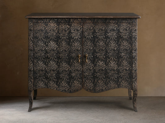 Amalfi Cabinet with intricate, hand-carved floral patterns on antique-finished wood, features two doors and curved legs.
