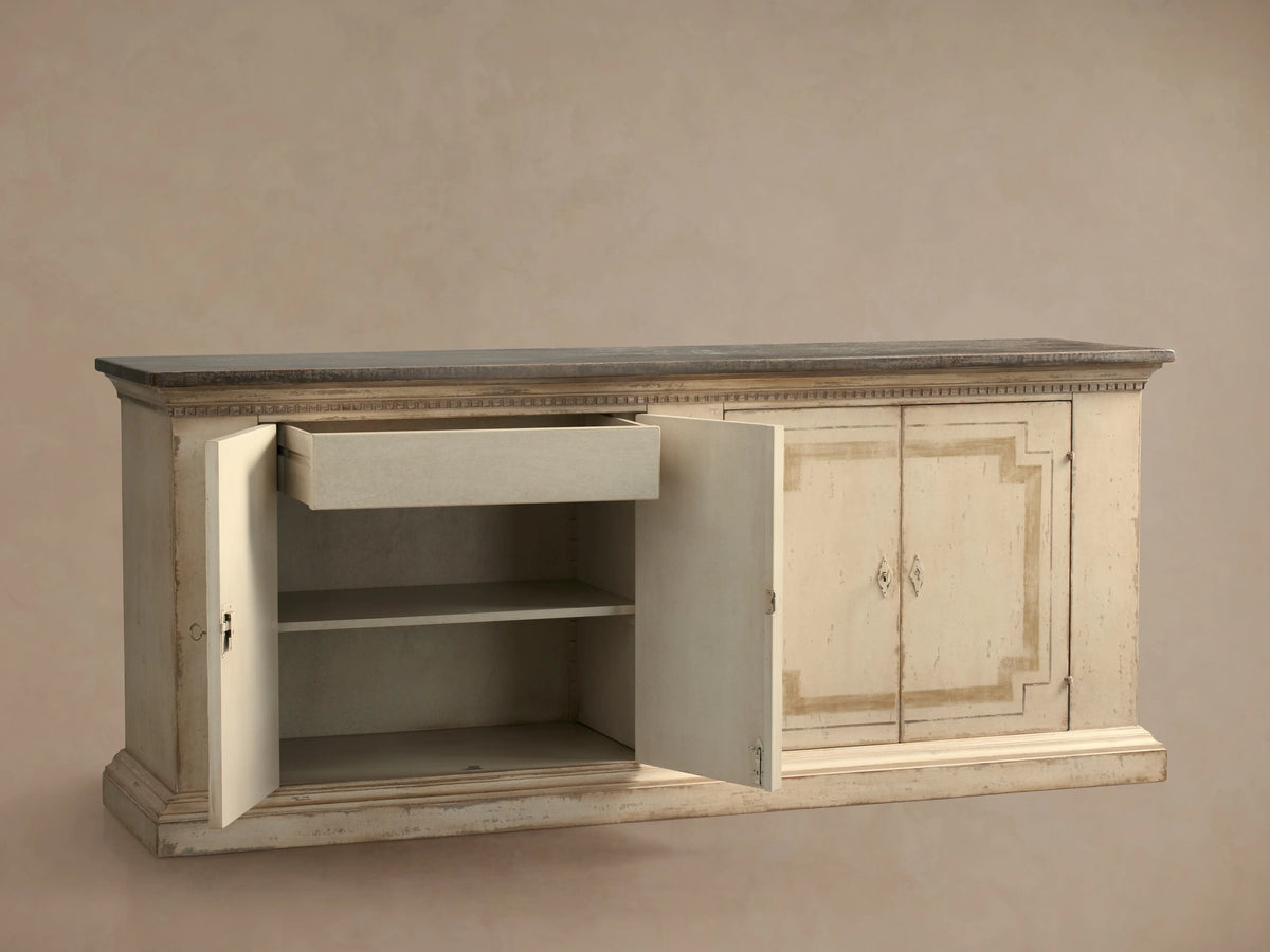 Oriana Buffet: distressed antique white buffet with dark top, two left doors open revealing shelves and a partially open drawer.