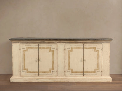 Hand-carved Oriana Buffet with distressed cream finish, showing four lockable doors with one open, revealing shelves inside.